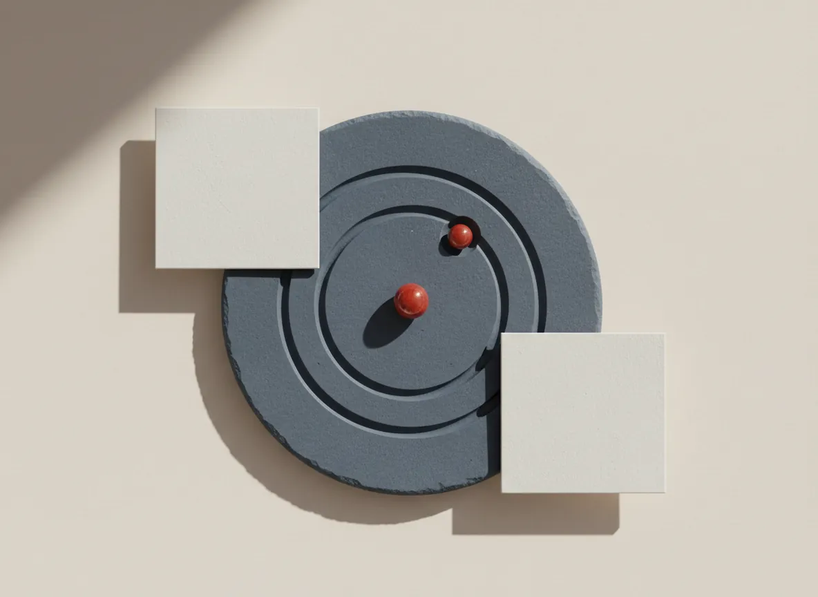 Still life: a slate disc with plain carved rings, two blank white cards and a red marble